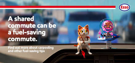 A toy cat and alien on a car dashboard