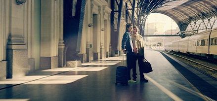 Two men standing at train platform