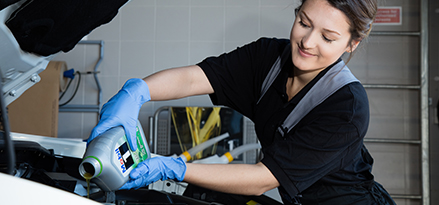 Woman topping up engine with Mobil 1 Oil.