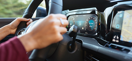Woman driving with two hands on steering wheel.