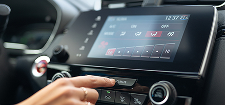 Person pressing button on car dashboard